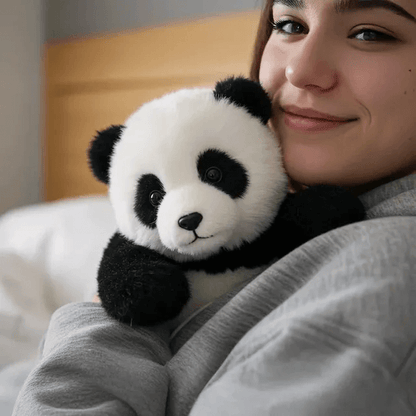 Person holding a plush panda toy in a cozy indoor setting